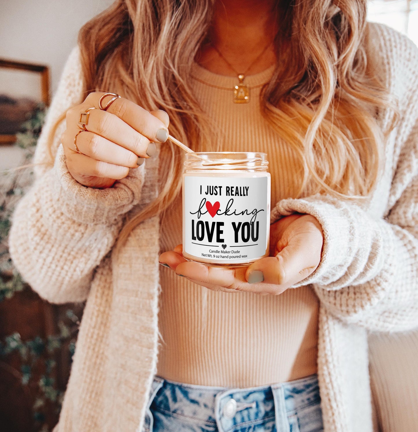 a woman holding a jar of love you candle