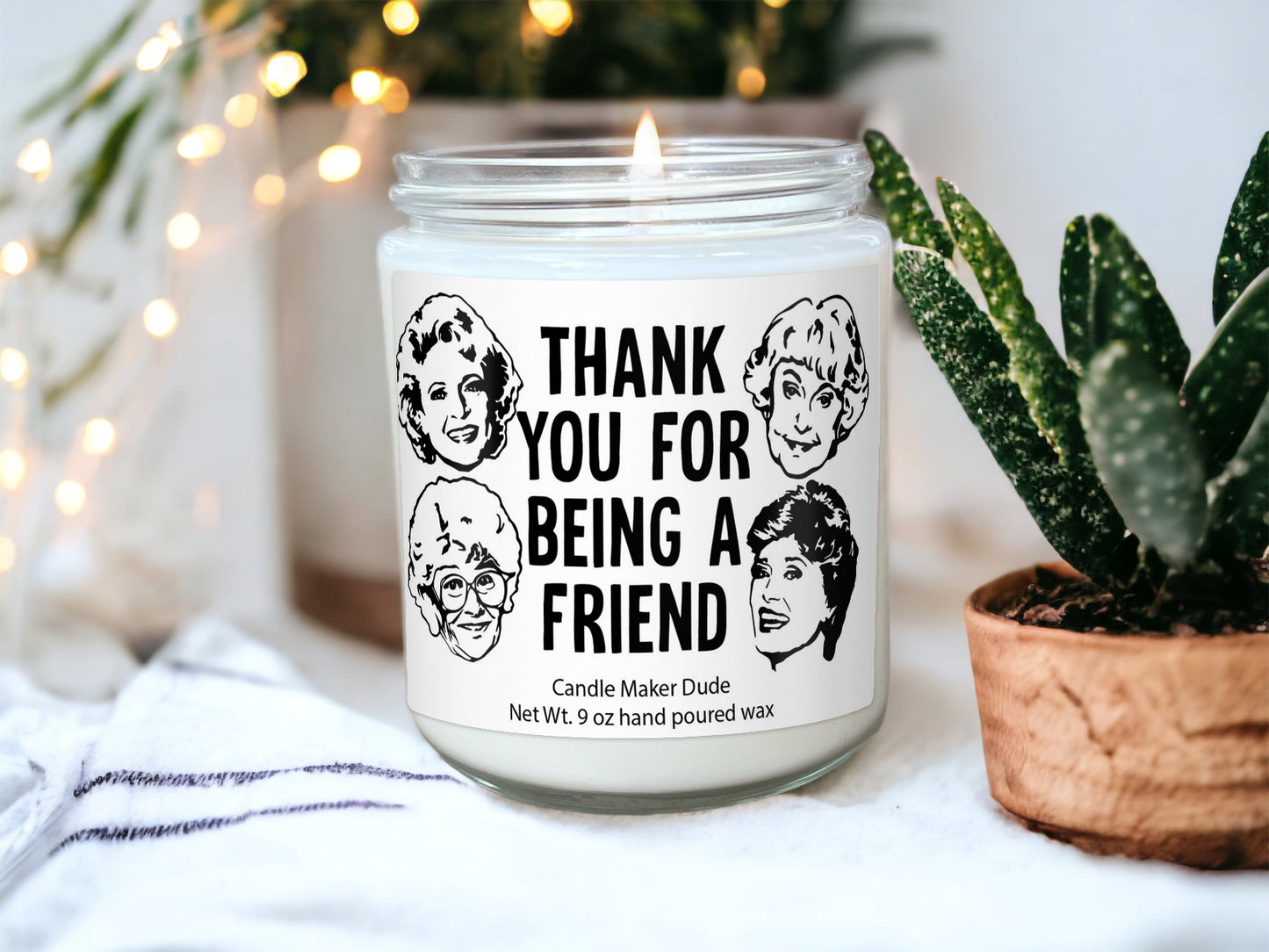 a candle that is sitting next to a potted plant