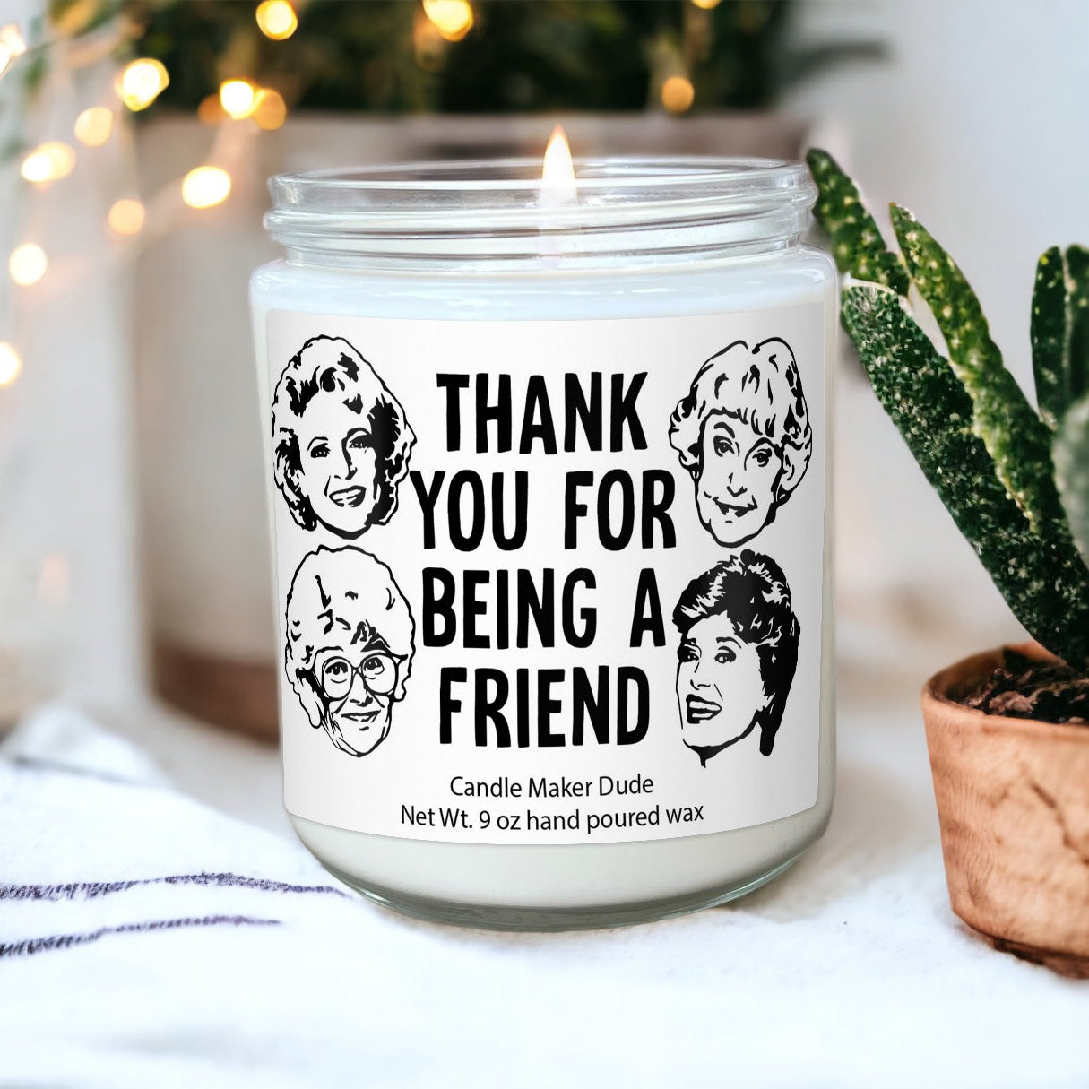 a candle that is sitting next to a potted plant