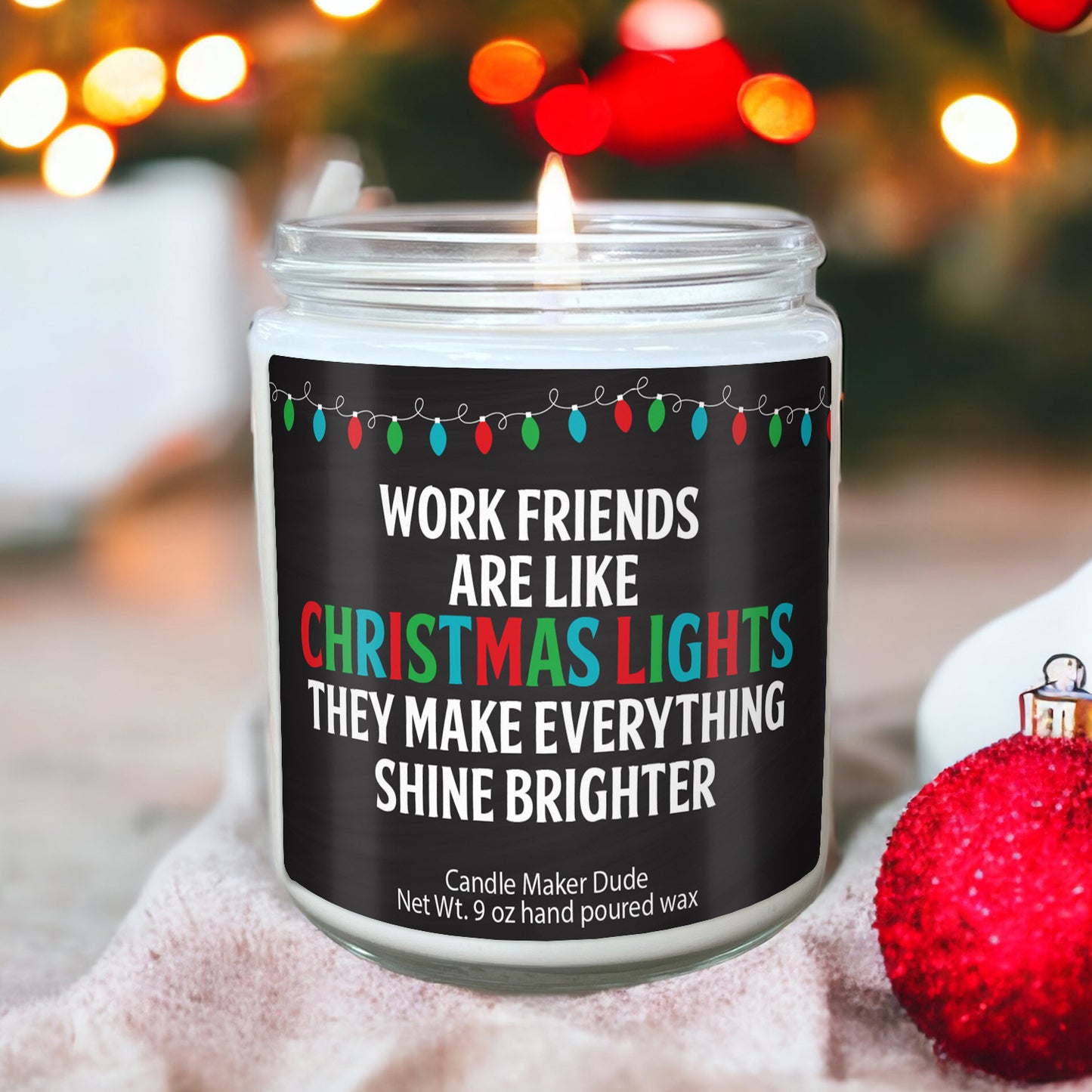 a candle with a christmas quote on it next to a christmas ornament